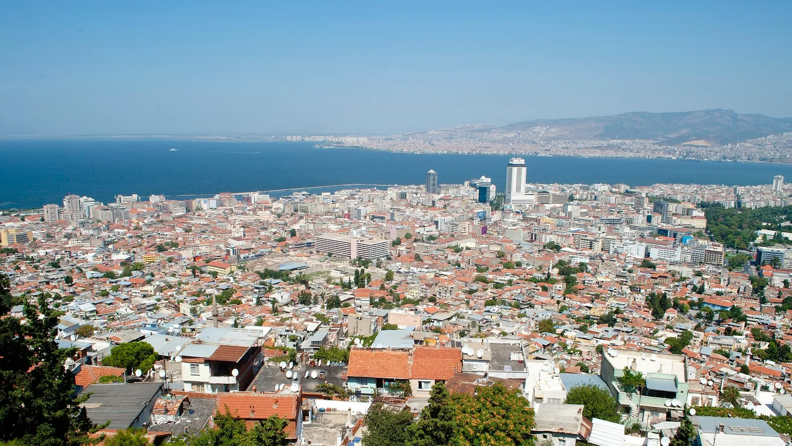 İzmir kıyısı, plajlar ve deniziyle geniş şehir manzarası. Karşıda Alsancak semti görülüyor.
