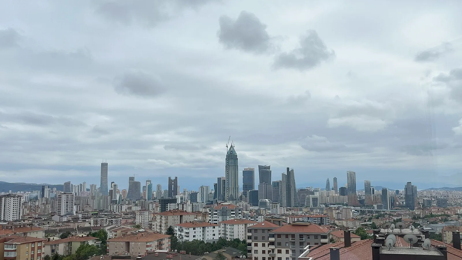 İstanbul'un merkezinde yüksek binalar ve turuncu çatılı ev.