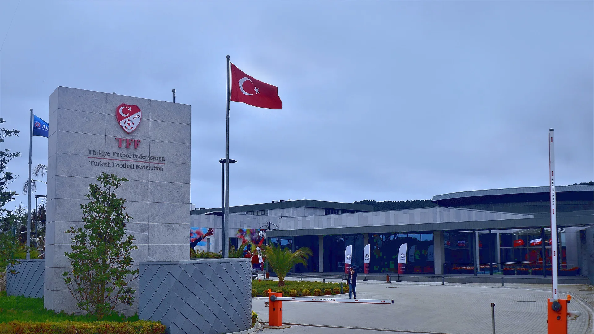Türkiye Futbol Federasyonu tabelası, bayraklar ve arkada cam cepheli tesis binası