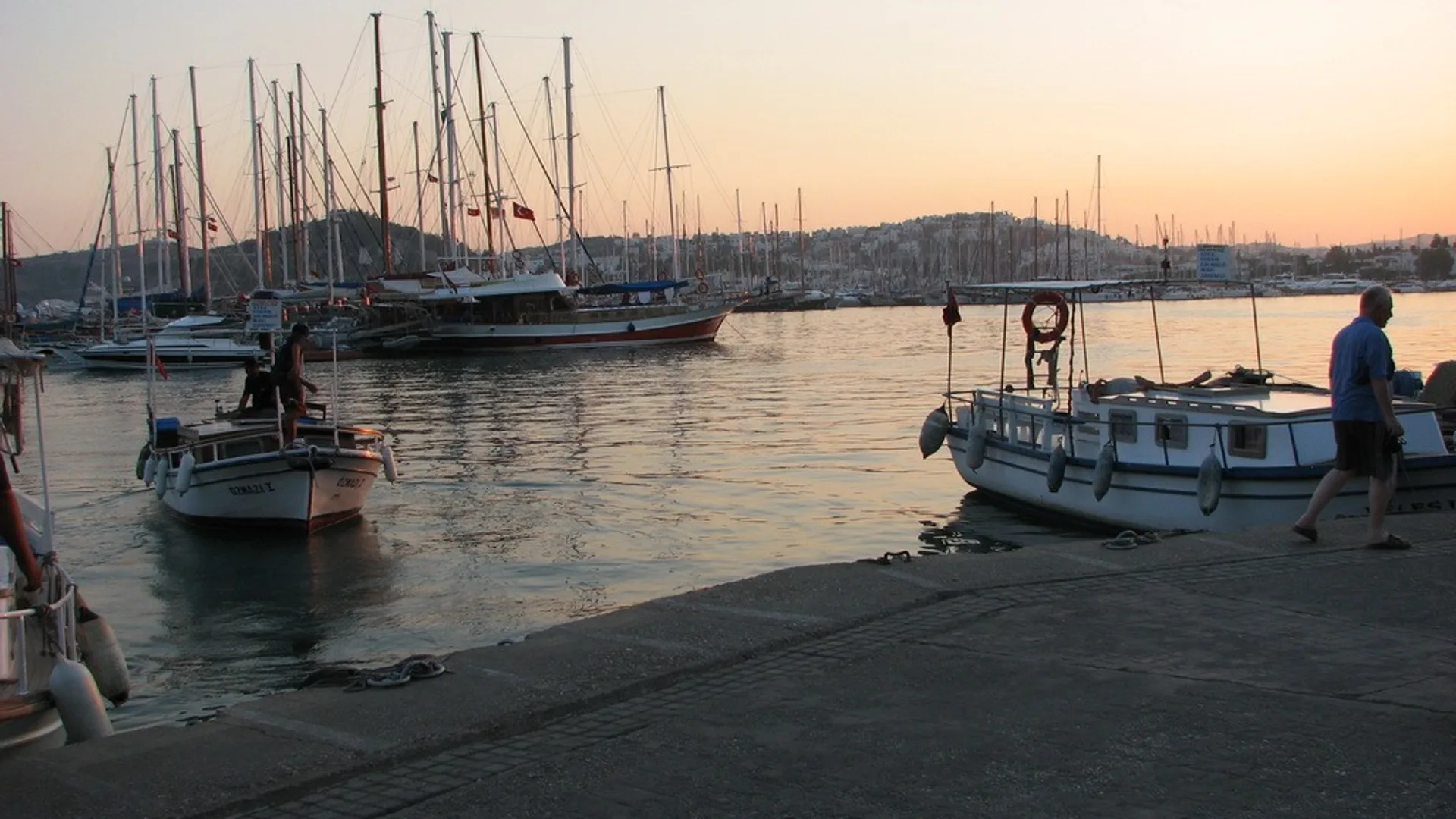 Bodrum limanında tekneler, yelkenli yatlar ve deniz manzarası.