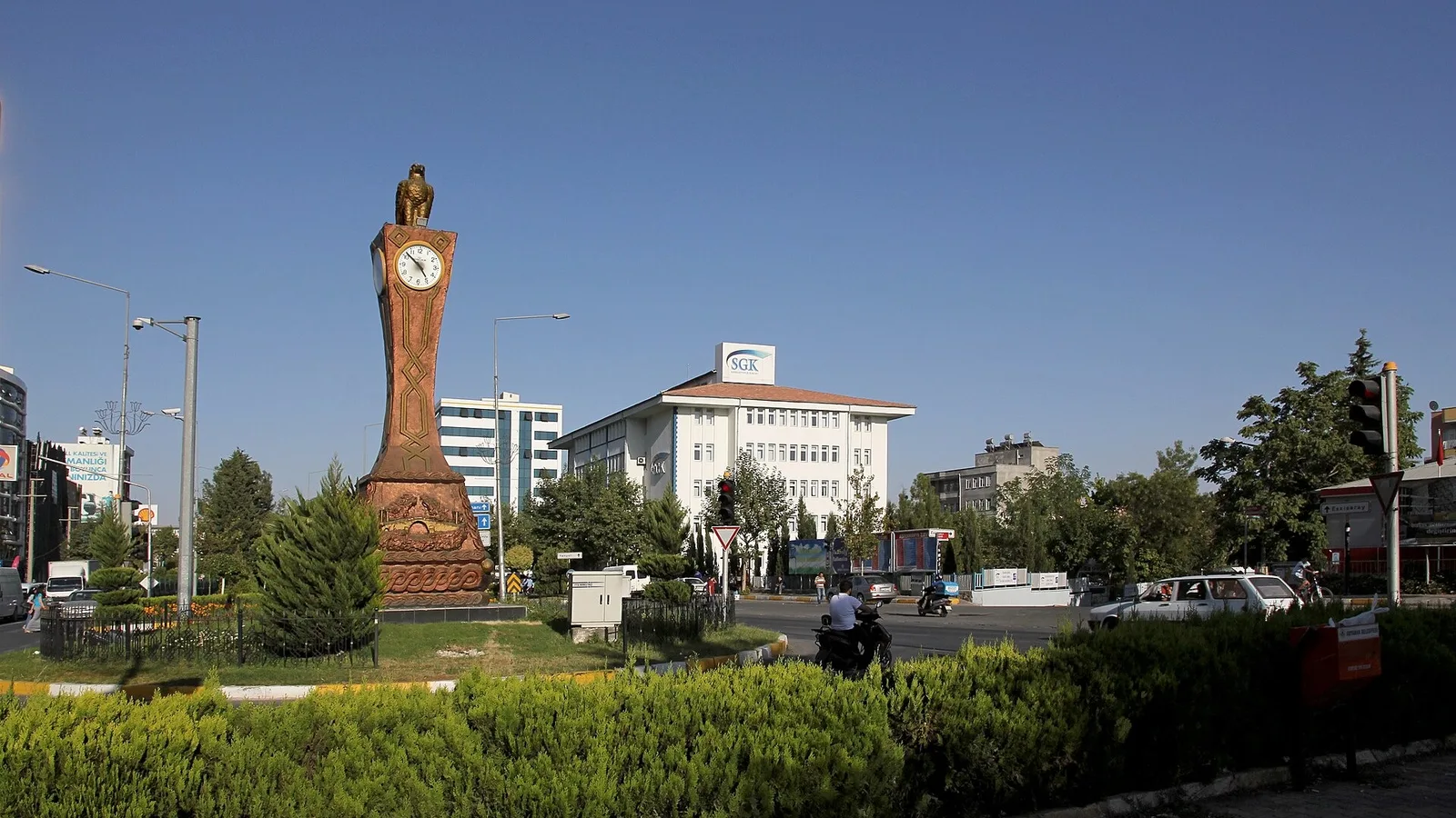 Adıyaman şehrinin merkezinde saatli anıt ve kamu binaları görseli.