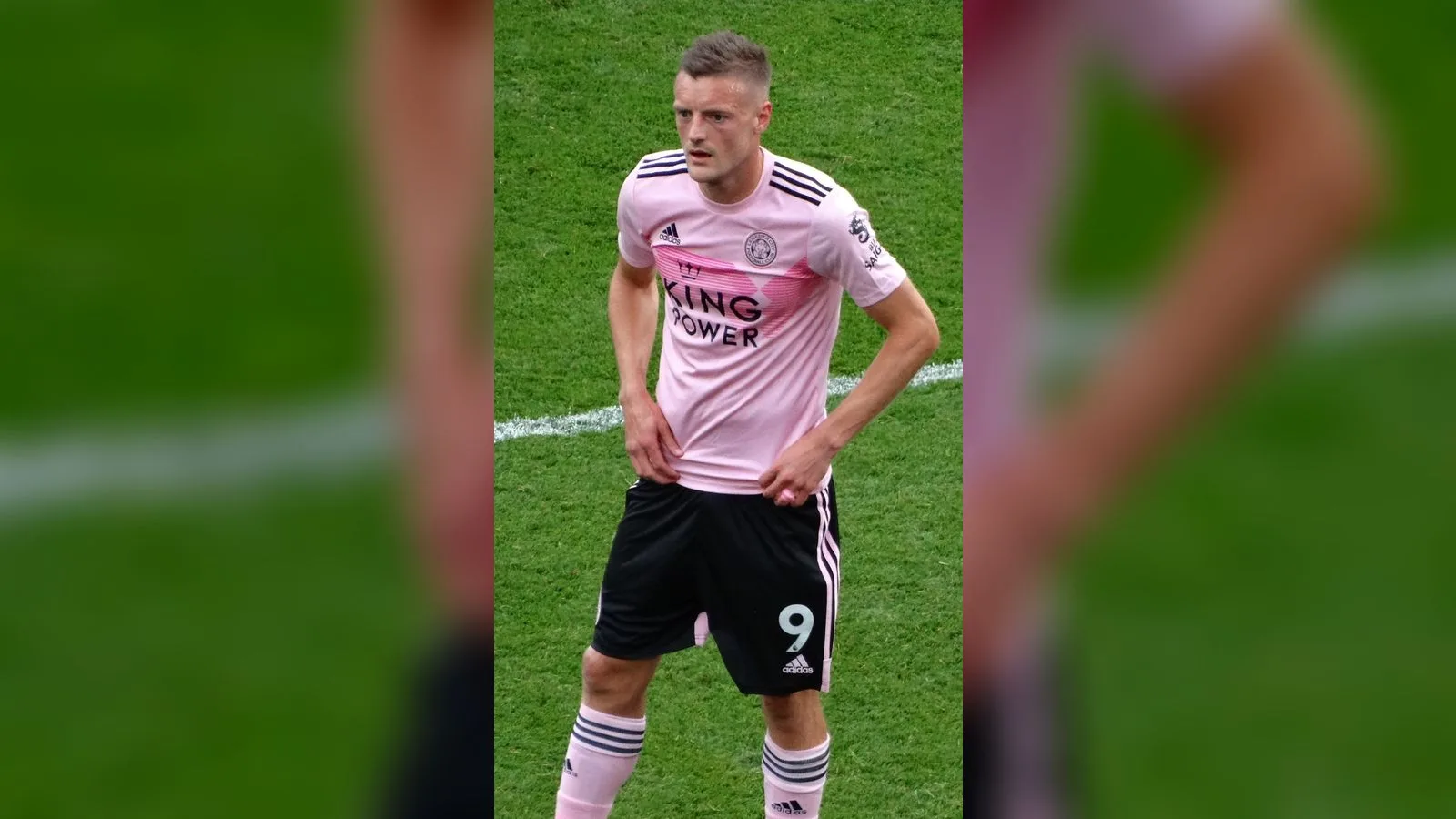 Pembe futbol forması giymiş, numarası 9 olan oyuncu çim sahada.