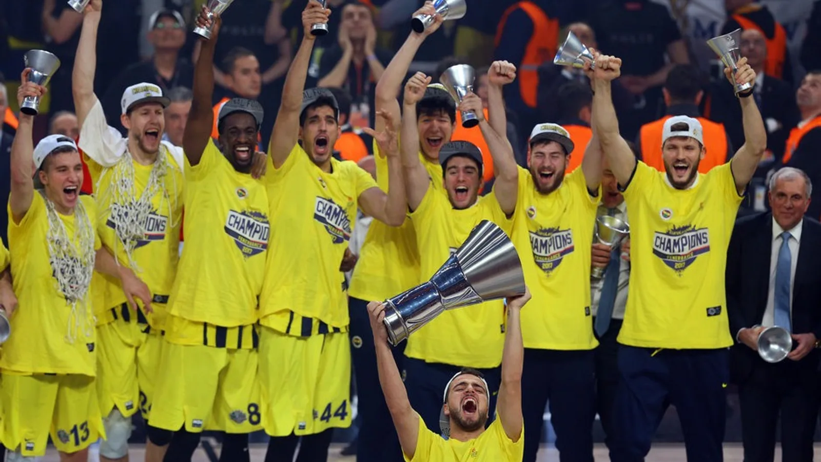 Sarı-lacivert formalı futbolcular kupayı kaldırarak kutlama yapıyor.
