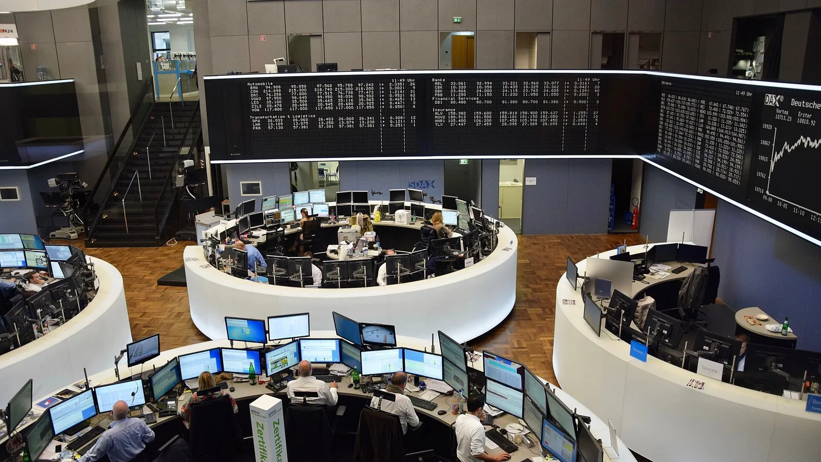 Borsa trading floor'u, analitiklerin ekranları ve monitörlerle çalıştıkları görseli.