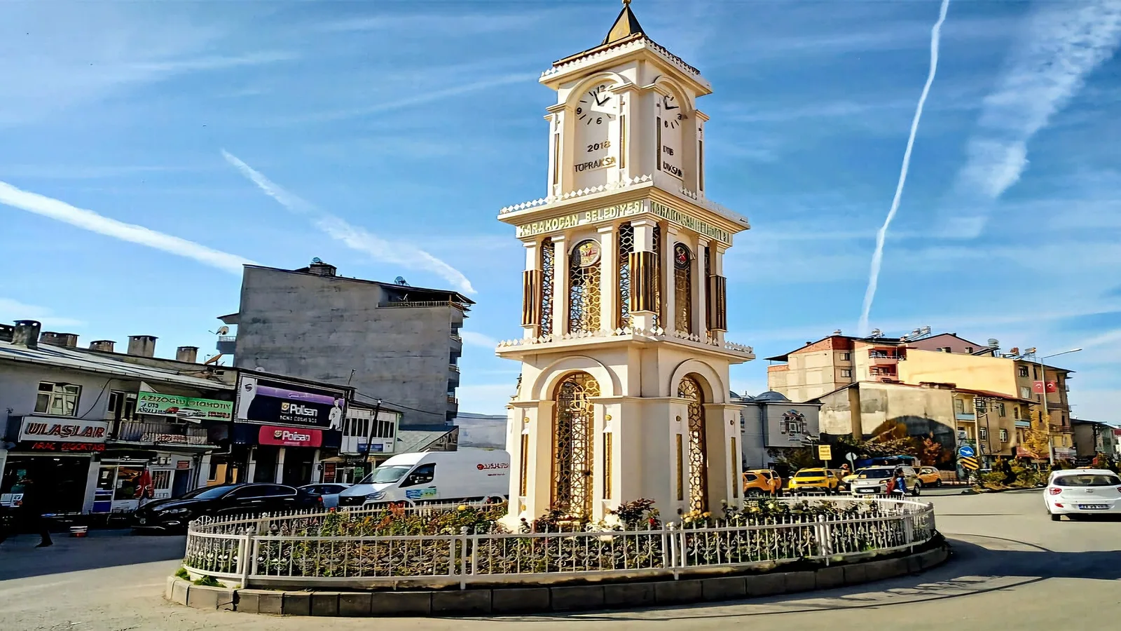 Karakoçan kasabası merkezindeki saat kulesinin günüş görünümü, ticari işletmelerin yanında.