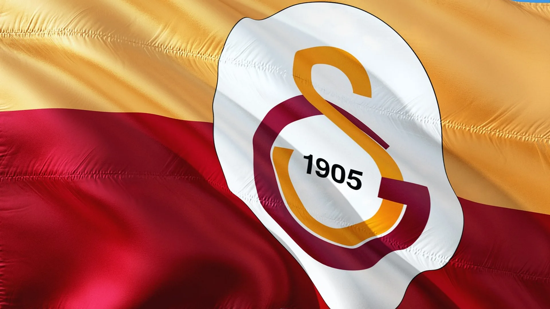 Sarı-kırmızı dalgalanan bayrak üzerinde 1905 yazılı Galatasaray arması