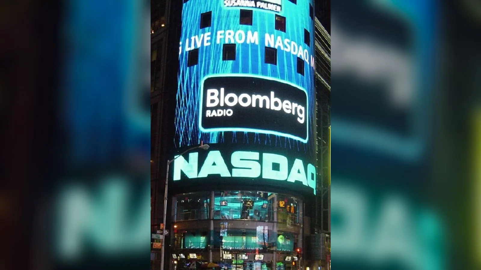 Nasdaq borsası binasının aydınlı cephesi, Bloomberg Radio yazısı görülüyor.