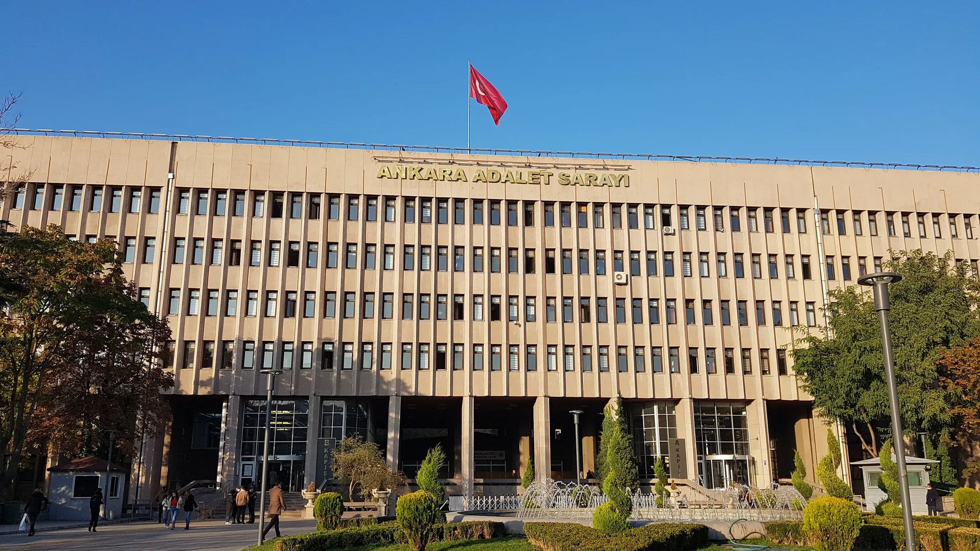 Çatısında Türk bayrağı dalgalanan, önü yeşil bahçeli çok katlı Ankara Adalet Sarayı binası