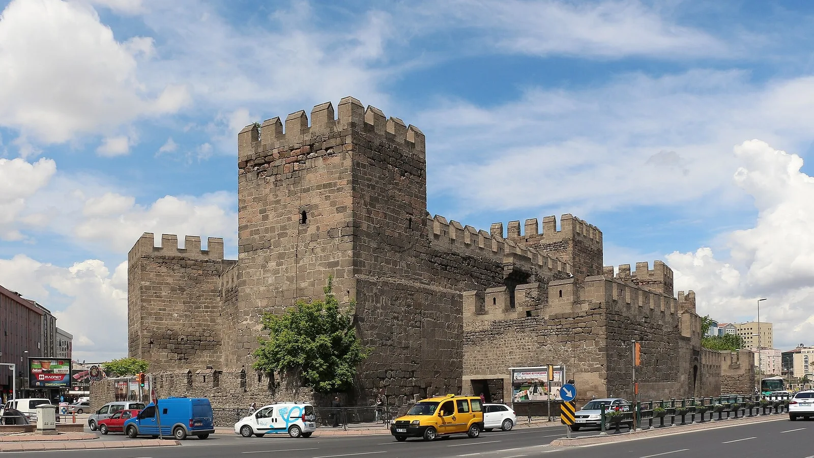 Kayseri Kalesi taş surları ve burçları ön planda, caddeler ve kent.