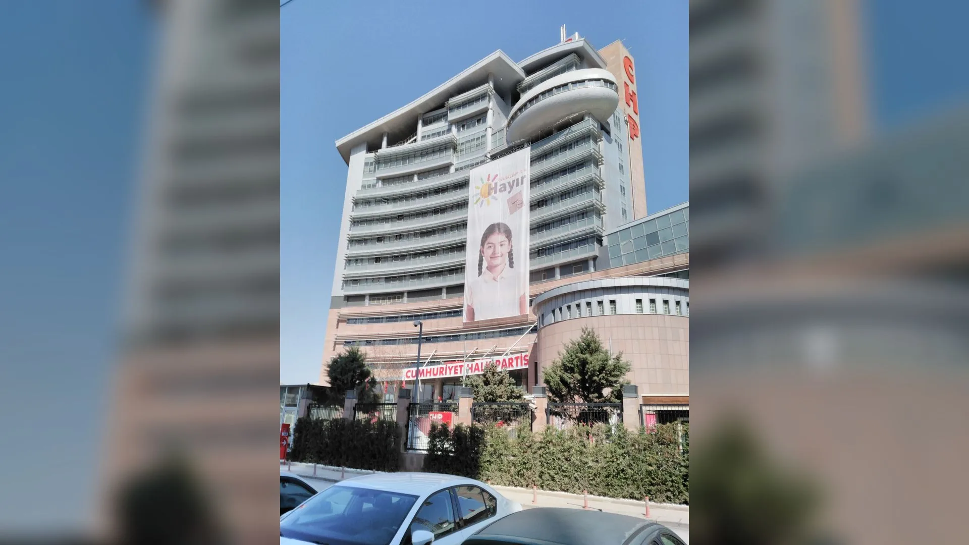 Cephesinde kız çocuğu afişi asılı çok katlı CHP genel merkez binası, önünde park etmiş arabalar