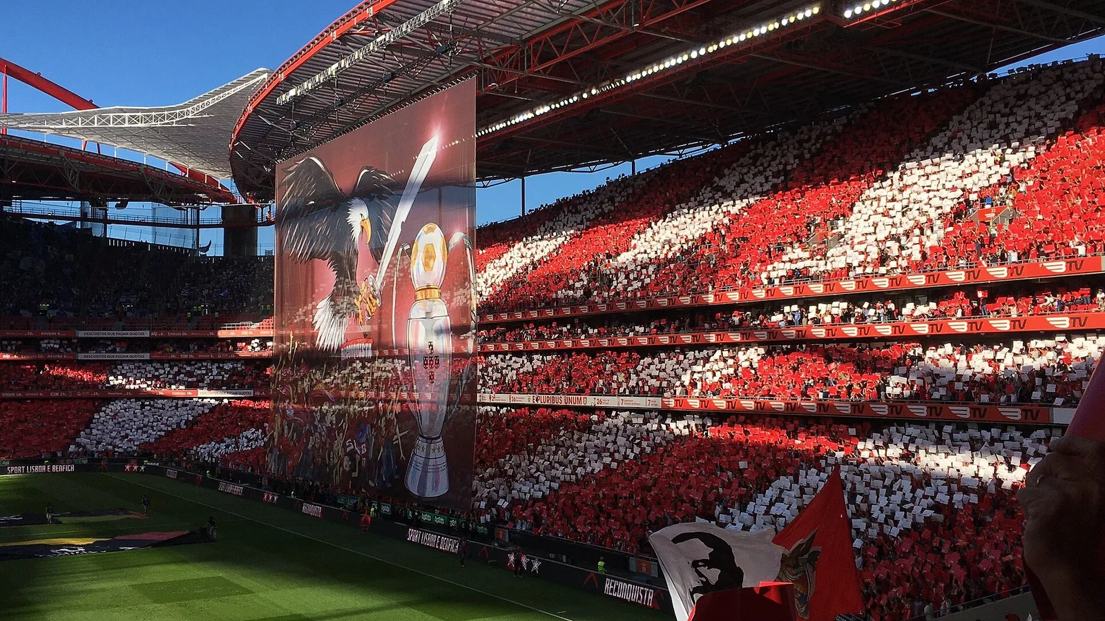 Kırmızı beyaz renklerde dolu stadyum tribünleri, merkez ekranda temsilatif görsel.