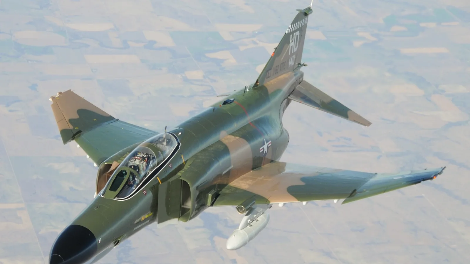 Hava gösterisinde serbest uçuş halindeki F-4 Phantom tipi askeri uçak, motoru yanında ve kanatları açık görünüyor.