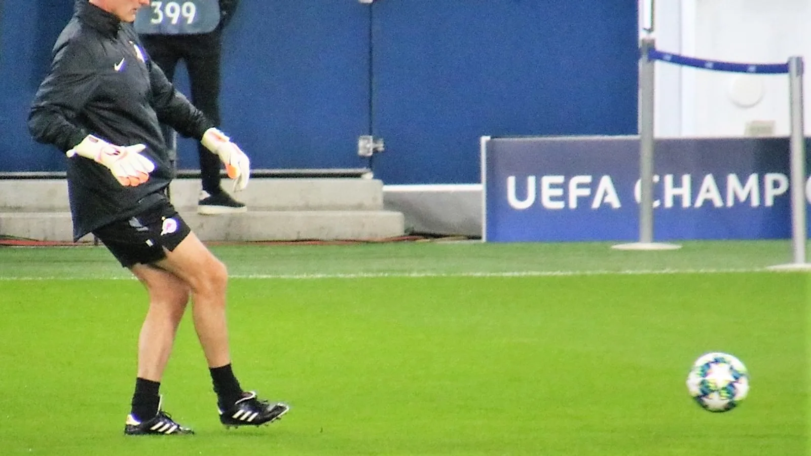 Siyah eşofmanlı yaşlı bir adam, UEFA Şampiyonlar Ligi stadyumunda antrenman.