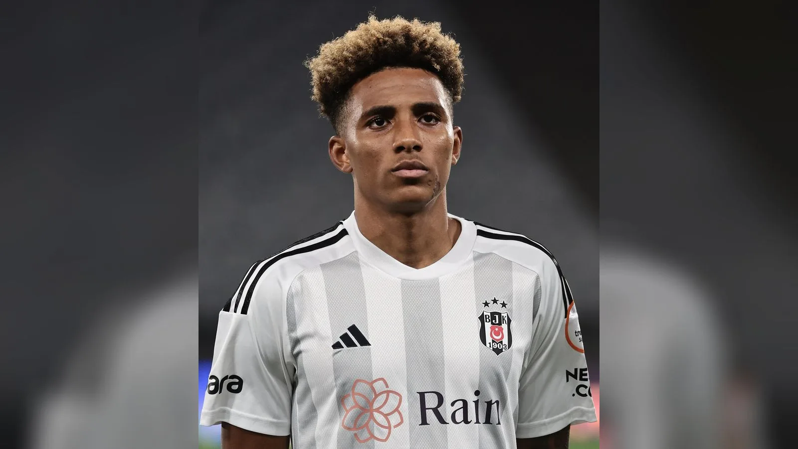 Beşiktaş JK forması giyen, sarı saçlı bir futbolcunun göğüs portesi.