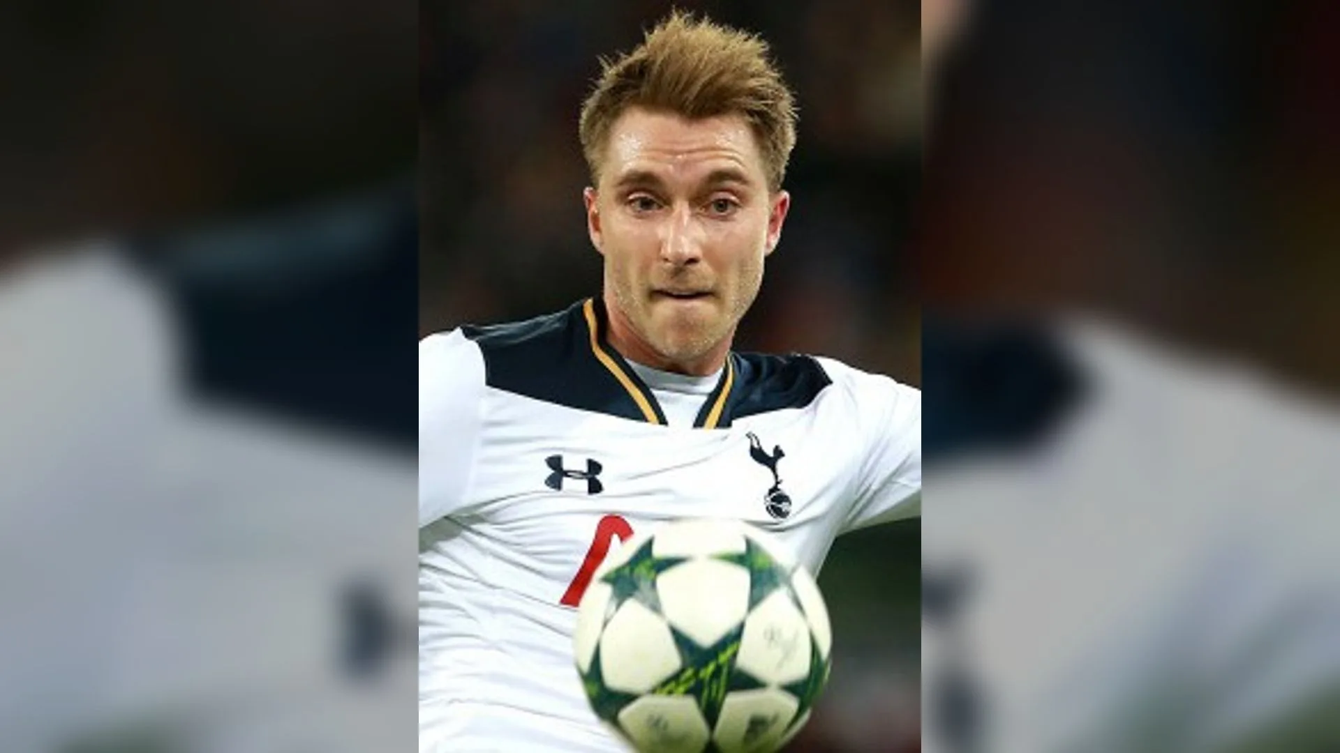 Tottenham Hotspur formasında futbolcu, top tutarken kameraya bakmakta.