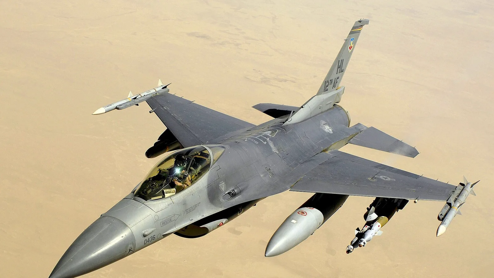 F-16 savaş uçağı uçuş gösterisinde hava görünüşü, kokpitte pilot görülüyor.