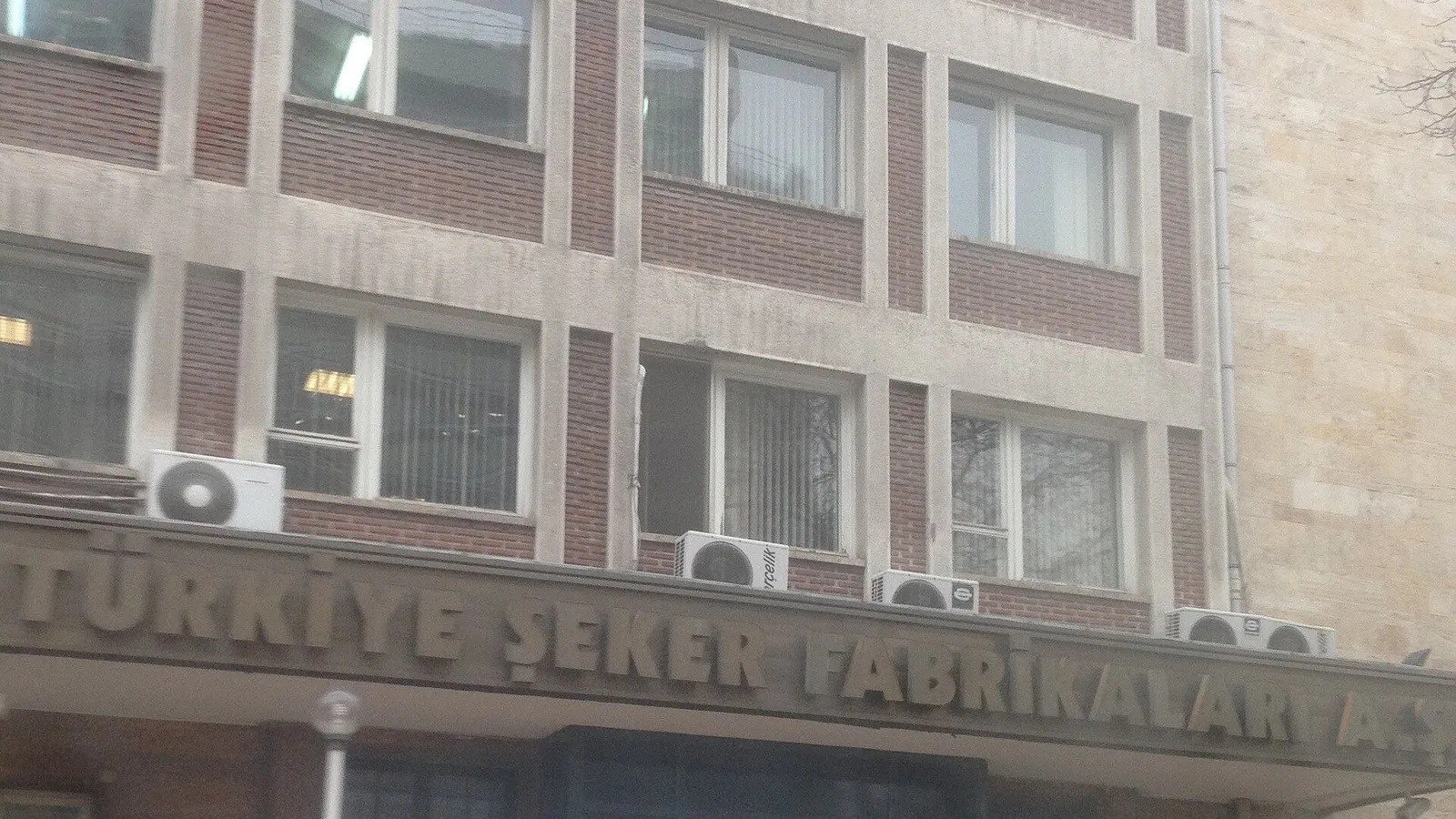 Tuğla ve cam pencereli çok katlı bir binanın cephesi.