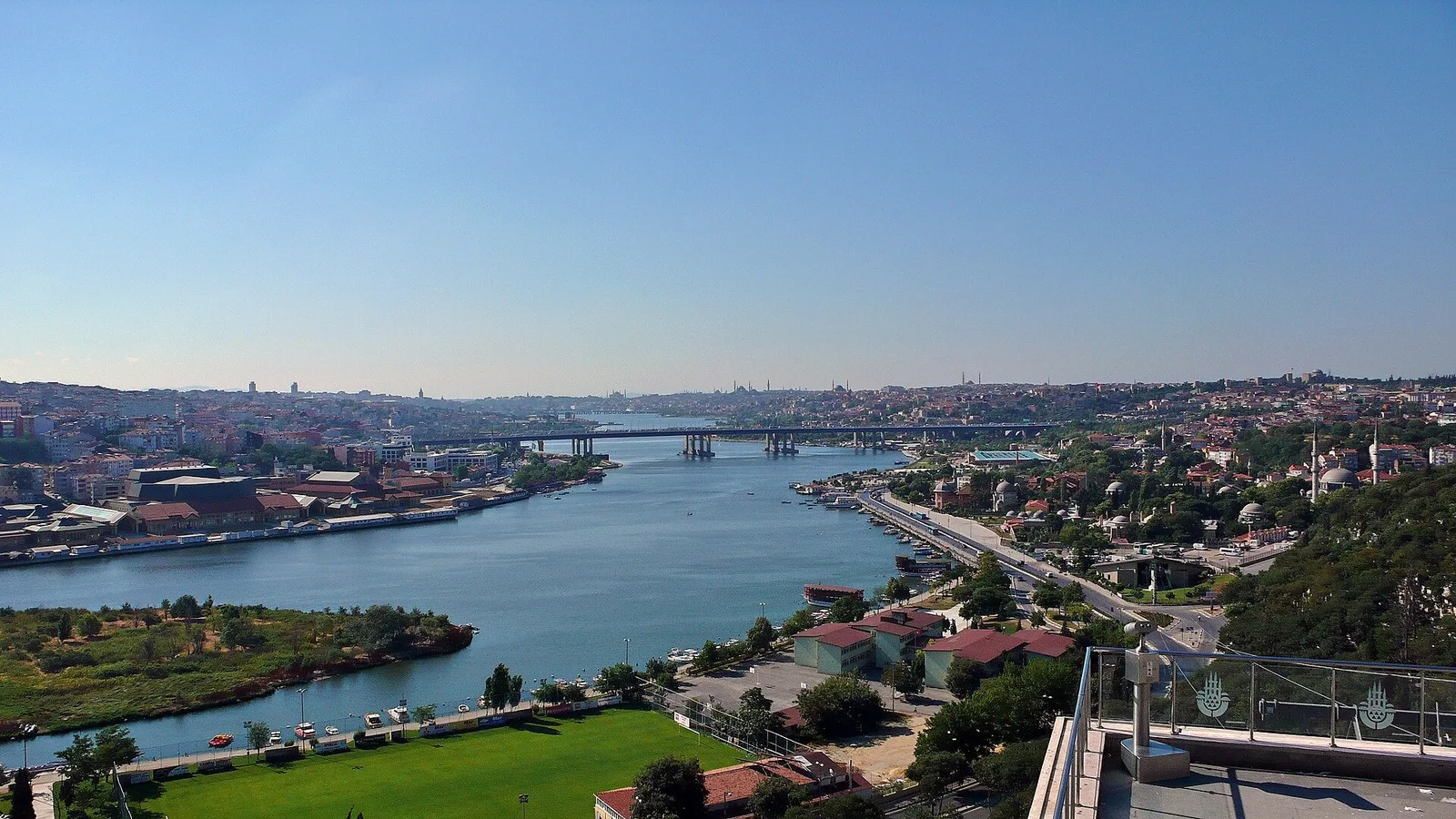 İstanbul boğazı, köprü ve yeşil sahralı kıyı görünümü.