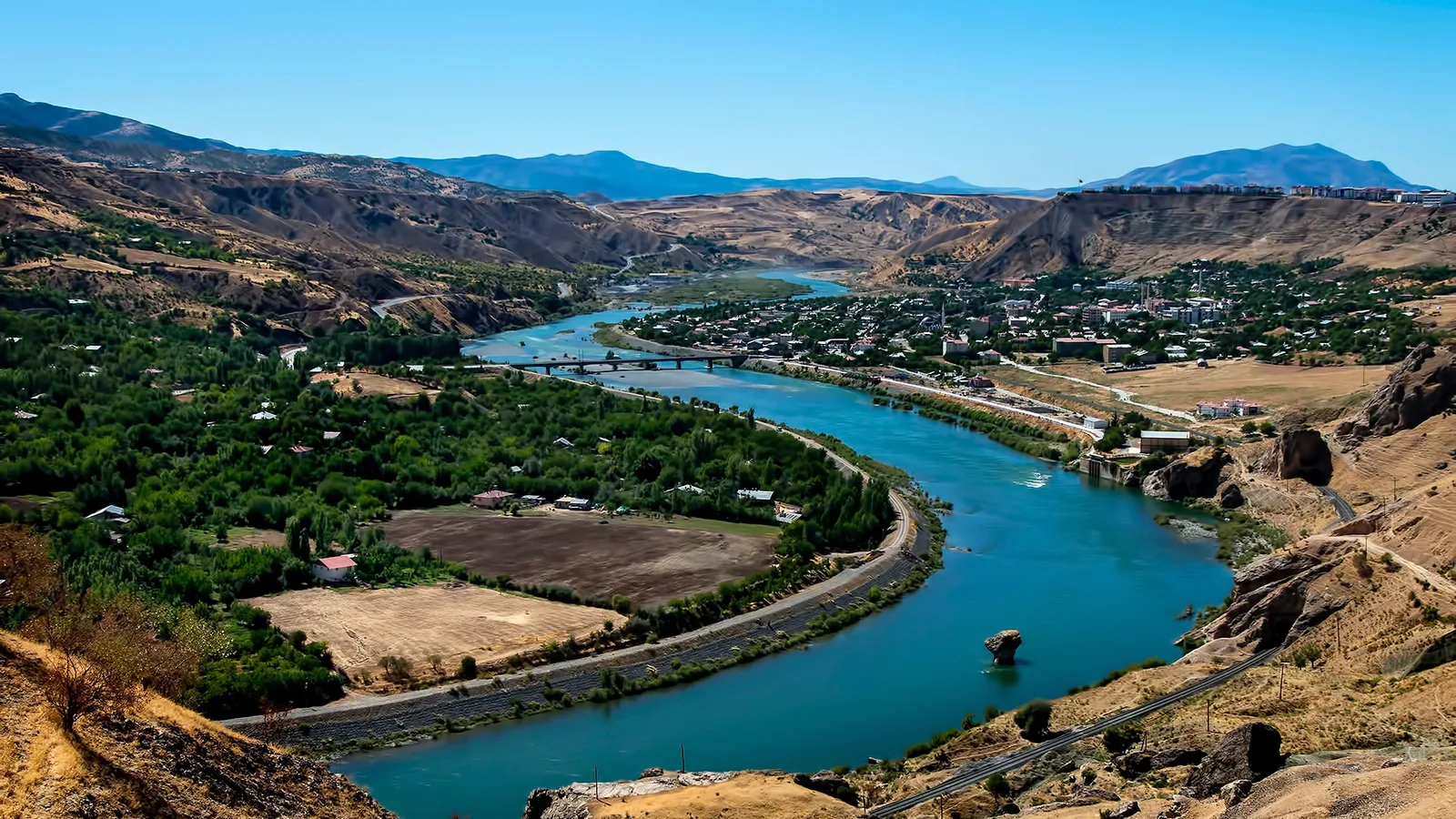 Firat Nehri'ni çevreleyen yeşil ormanlar ve dağlık Palu ilçesi manzarası.