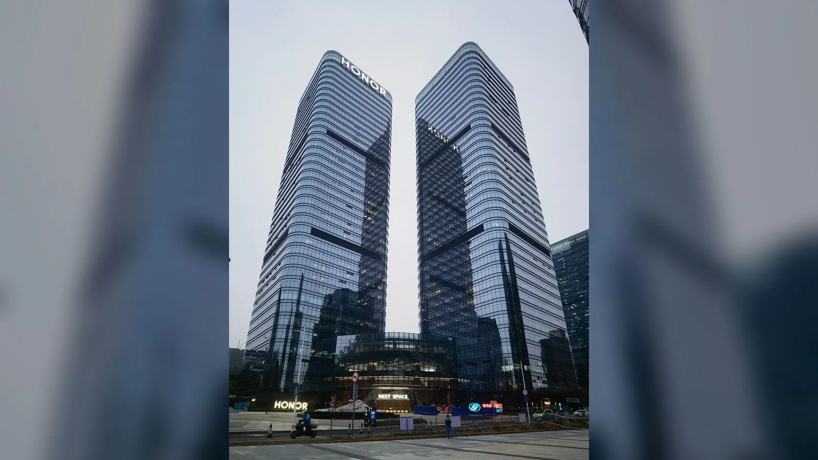 İki aynı yapı, cam ve metal cepheli, gümüş-mavi renkli çift kulelerin ön görünüşü gündüz ışığında.