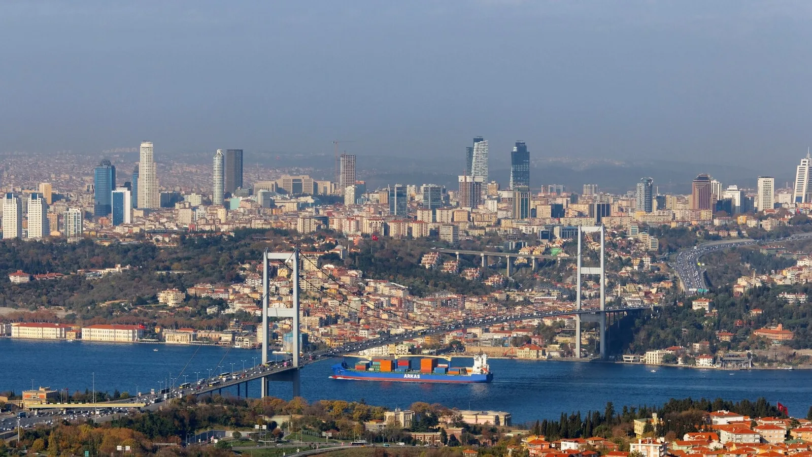 İstanbul'un hava görüntüsü; şehir silueti, mavi deniz, boğaz köprüsü ve gemi.
