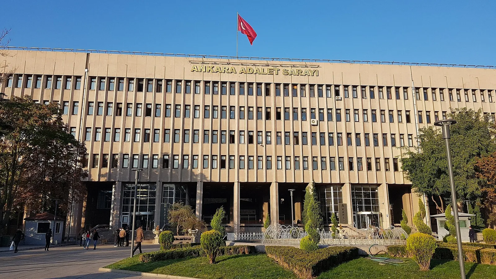 Ankara Adalet Sarayı binasının geniş cephesi, Türk bayrağı ve çelik kapılar görülüyor.