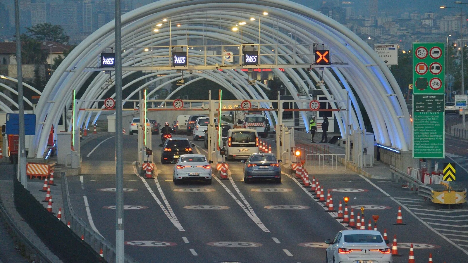 Avrasya Tüneli'nin giriş portalı, trafikte araçlar geçiyor, arka planda İstanbul manzarası.