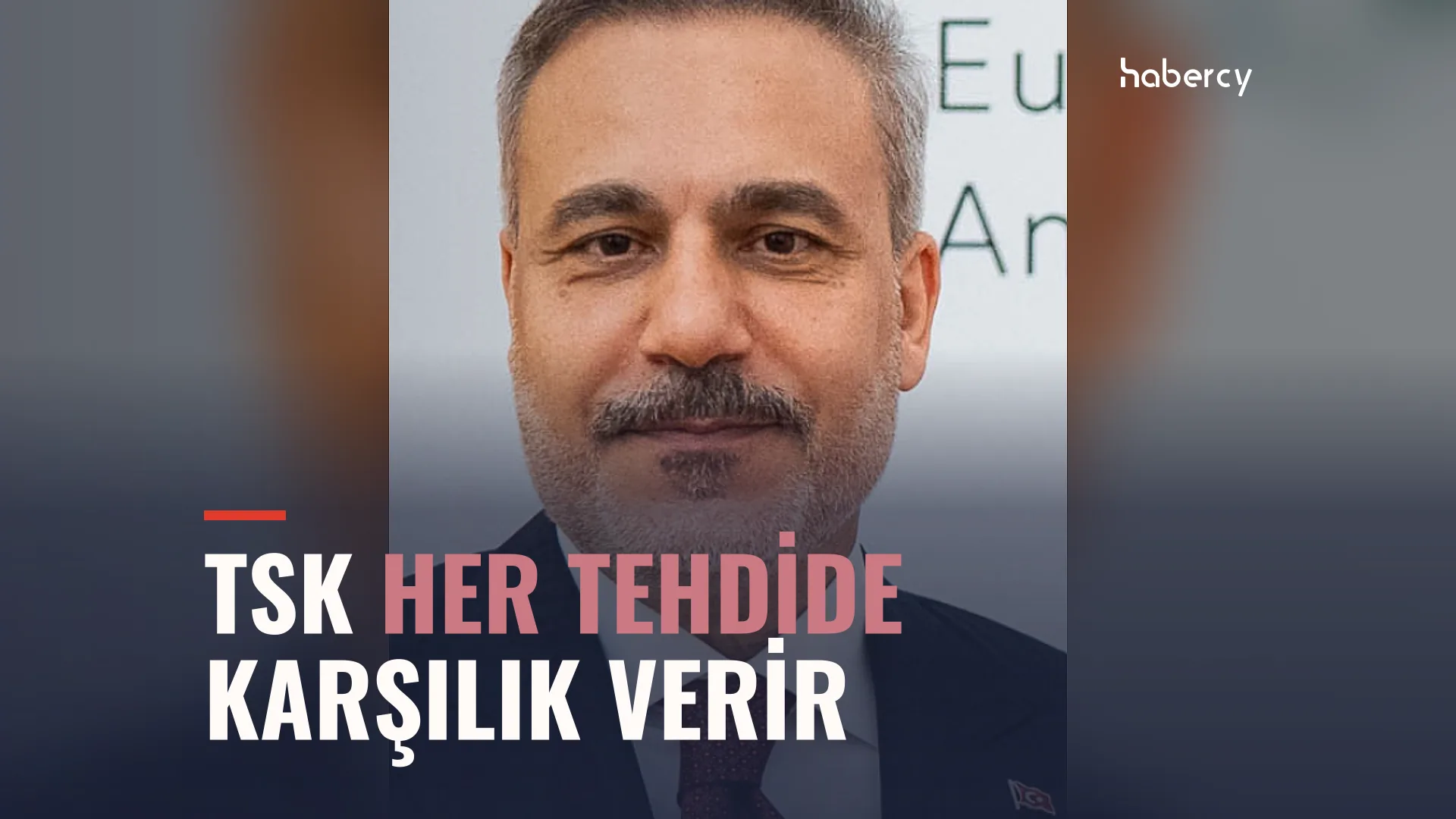 Kır saçlı, bıyıklı, koyu takım elbiseli bir adamın yakın portresi