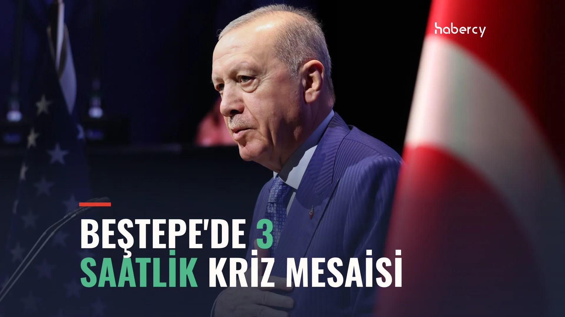 Lacivert takım elbiseli, bıyıklı yaşlı bir adam, arkasında Türk bayrağı