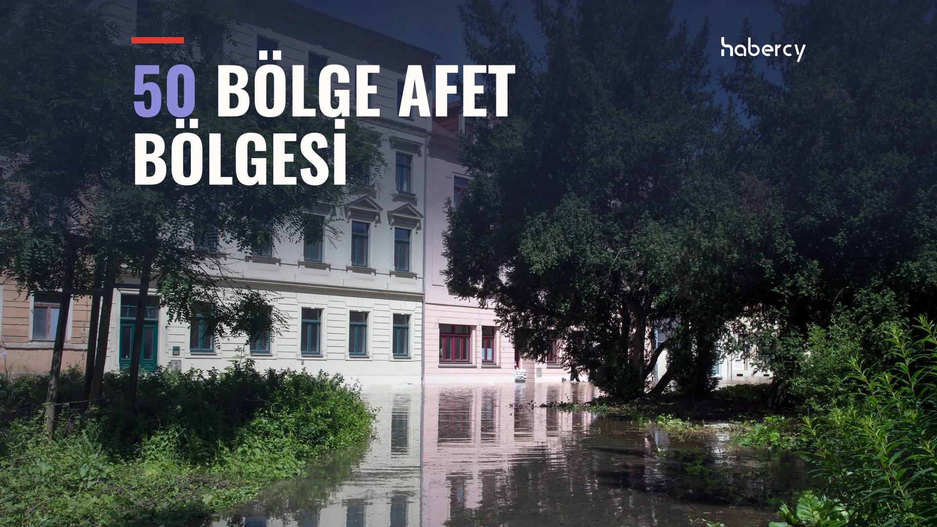 Ağaçlar arasında, sular altında kalmış bir sokak ve suya yansıyan eski binalar