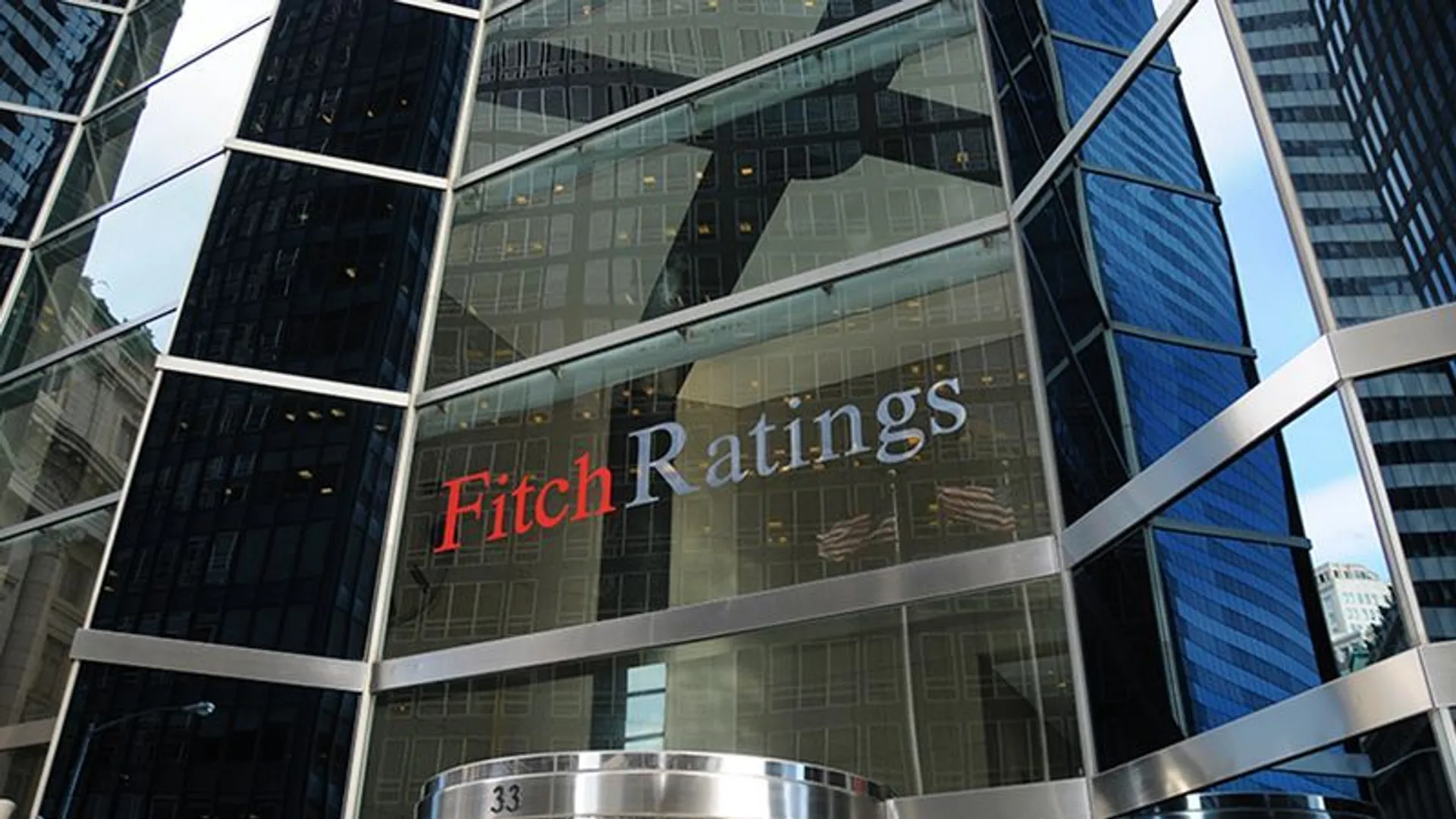 Cam kaplı bir gökdelenin cephesinde kırmızı ve gri harflerle Fitch Ratings logosu