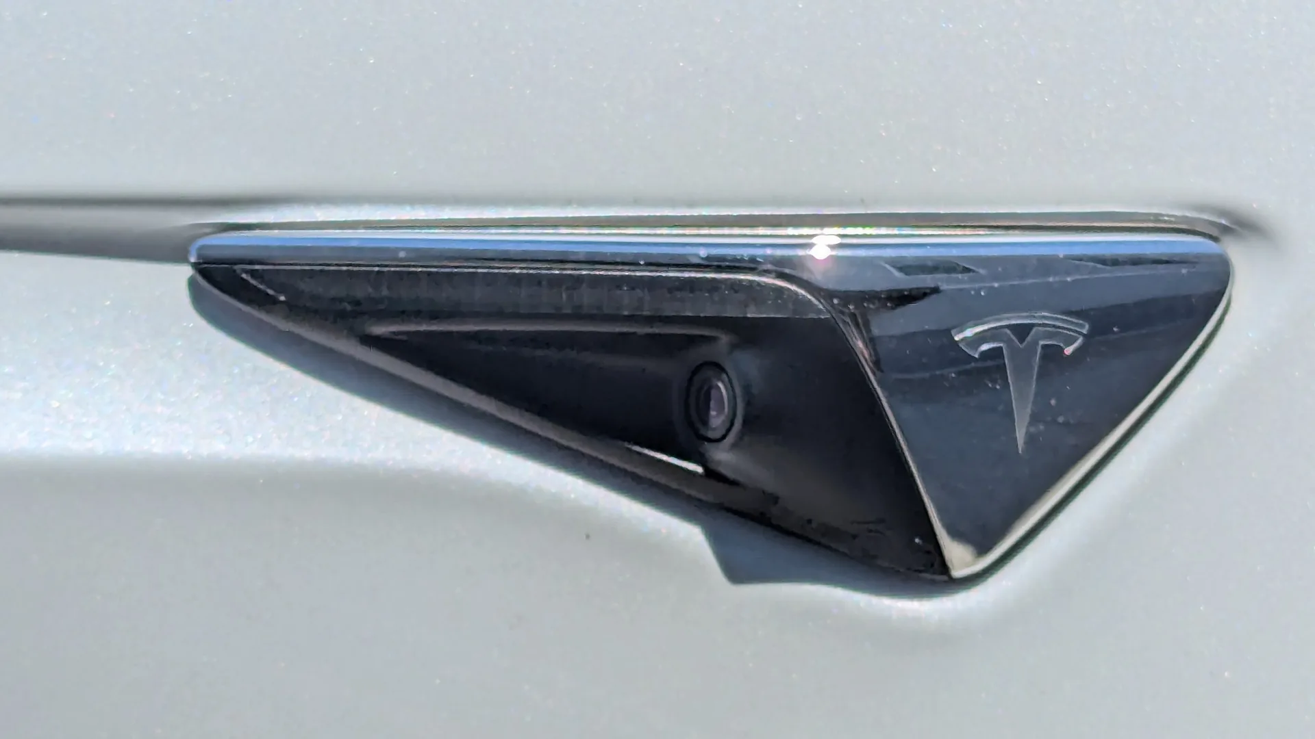 Beyaz bir elektrikli otomobilin yan gövdesindeki sürüş destek kamerası