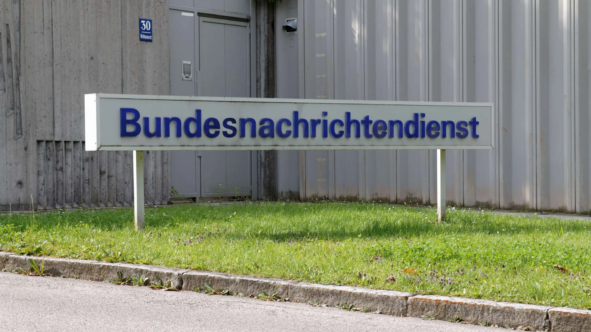 Metal çit önünde mavi harflerle Bundesnachrichtendienst yazan tabela
