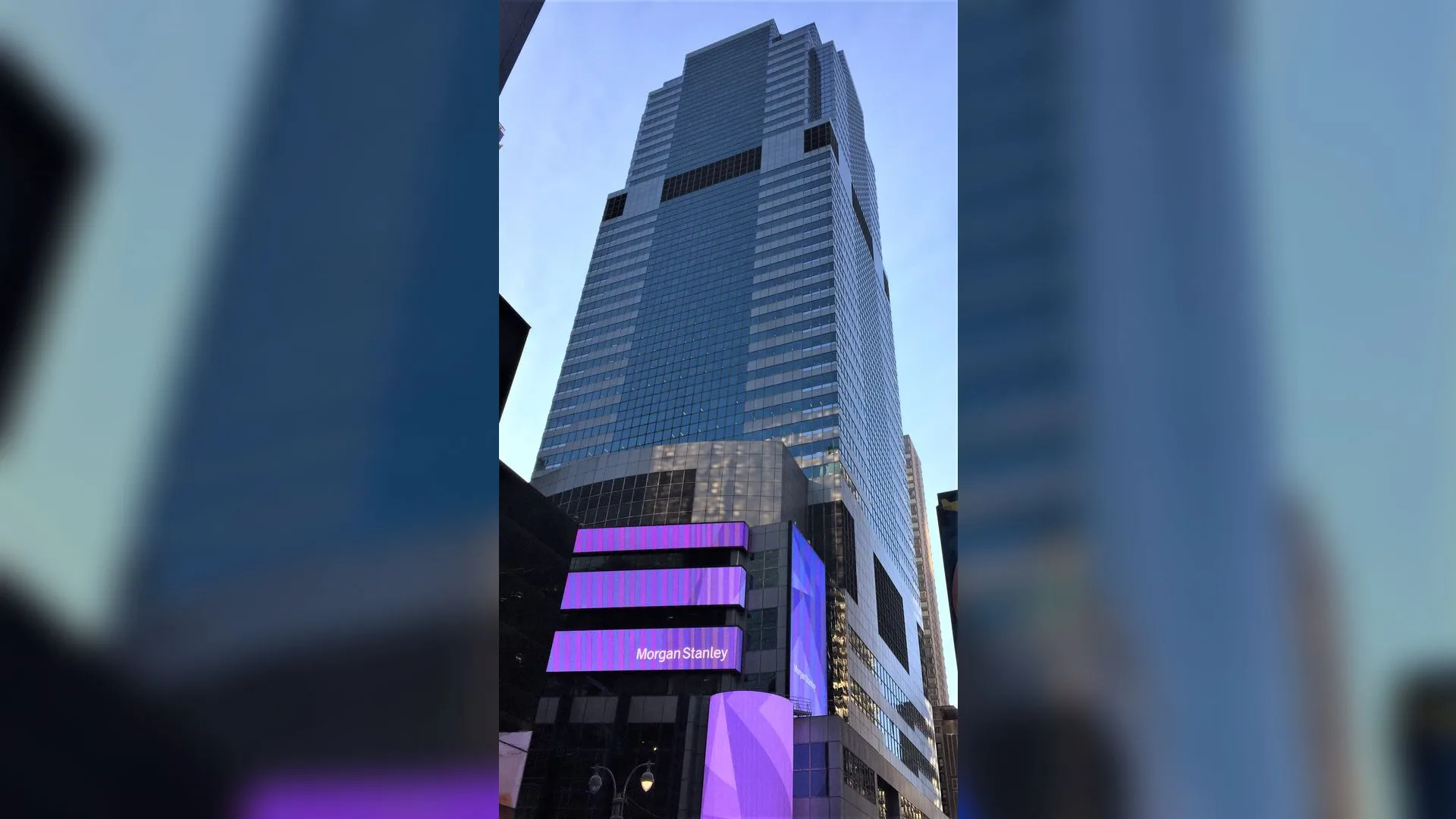 Times Square'de mor ışıklı Morgan Stanley tabelalı cam gökdelen