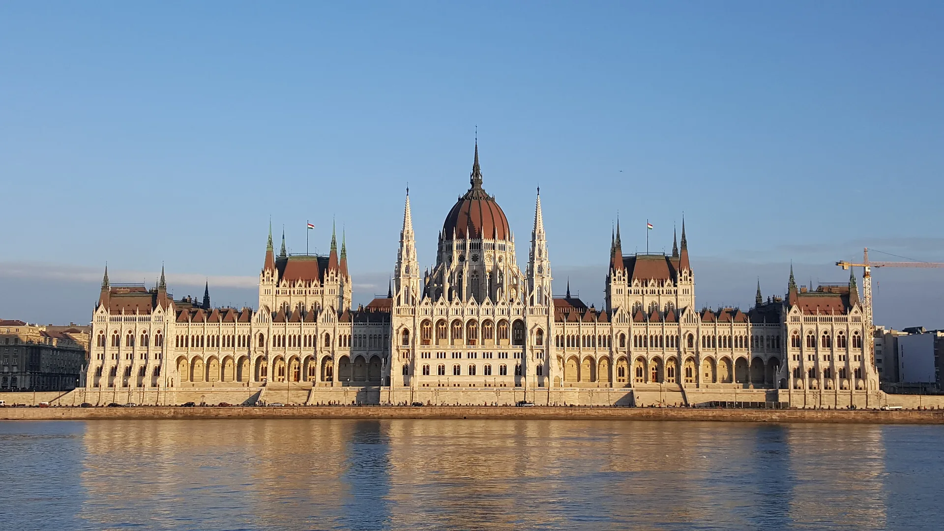 Tuna Nehri kıyısında, kubbeli ve sivri kuleli neogotik parlamento binası gün ışığında