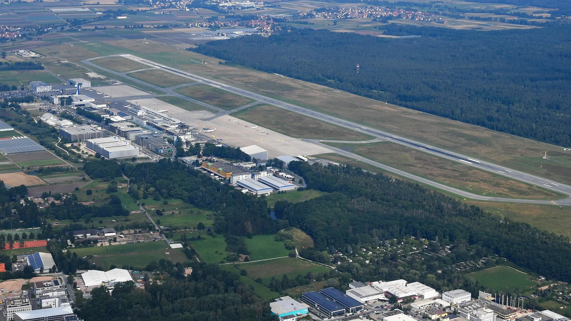 Ormanla çevrili havalimanı pisti ve terminal binalarının havadan görünümü