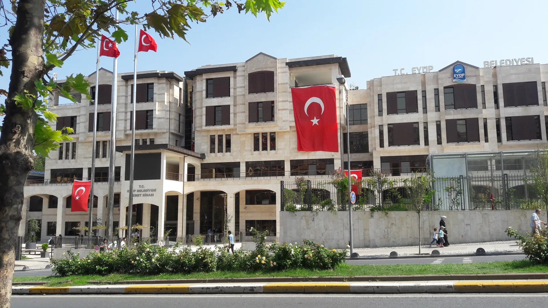 Türk bayraklarıyla süslü çok katlı taş kaplı belediye binası