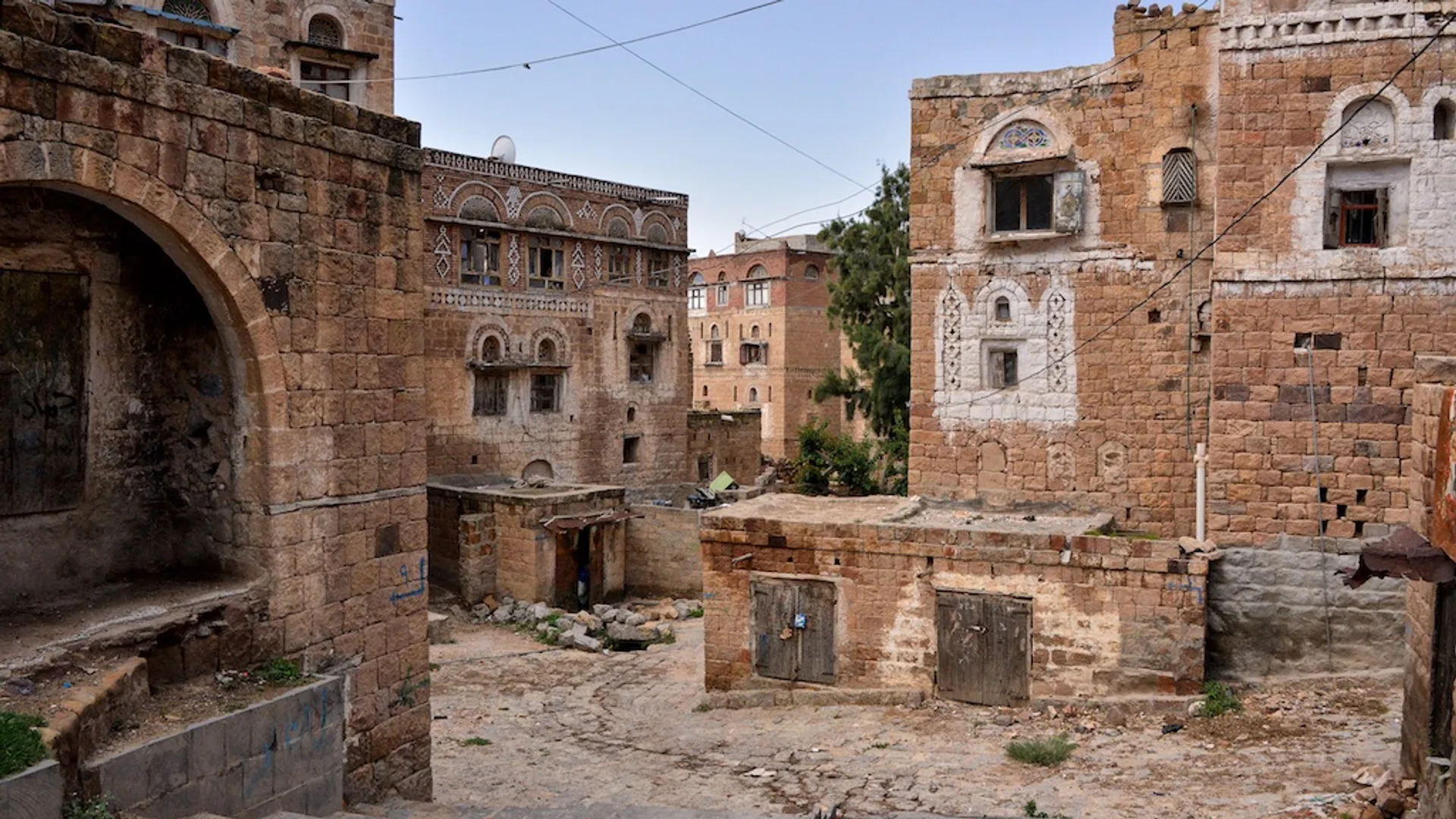 Dar bir sokağın çevresinde süslü pencereli, taştan yapılmış geleneksel çok katlı evler