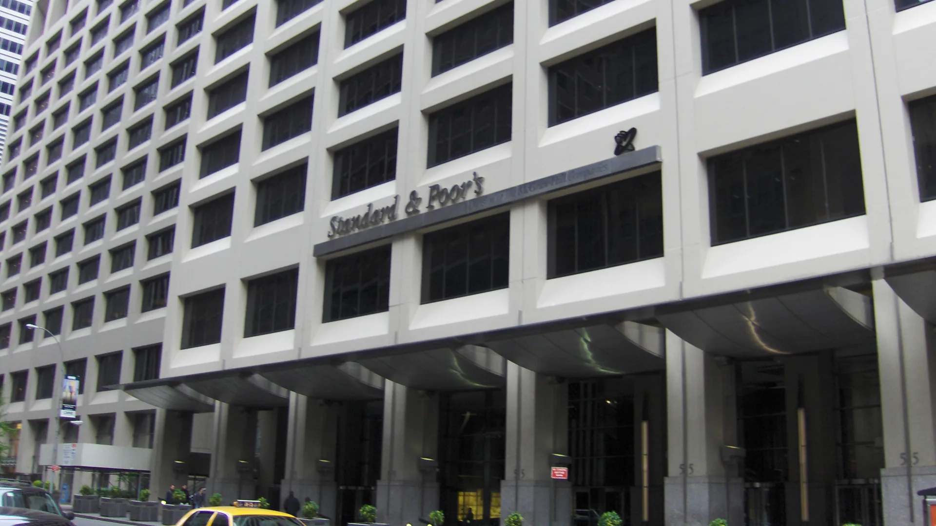 Girişinde Standard & Poor's yazısı bulunan, çok katlı beyaz ofis binasının cephesi