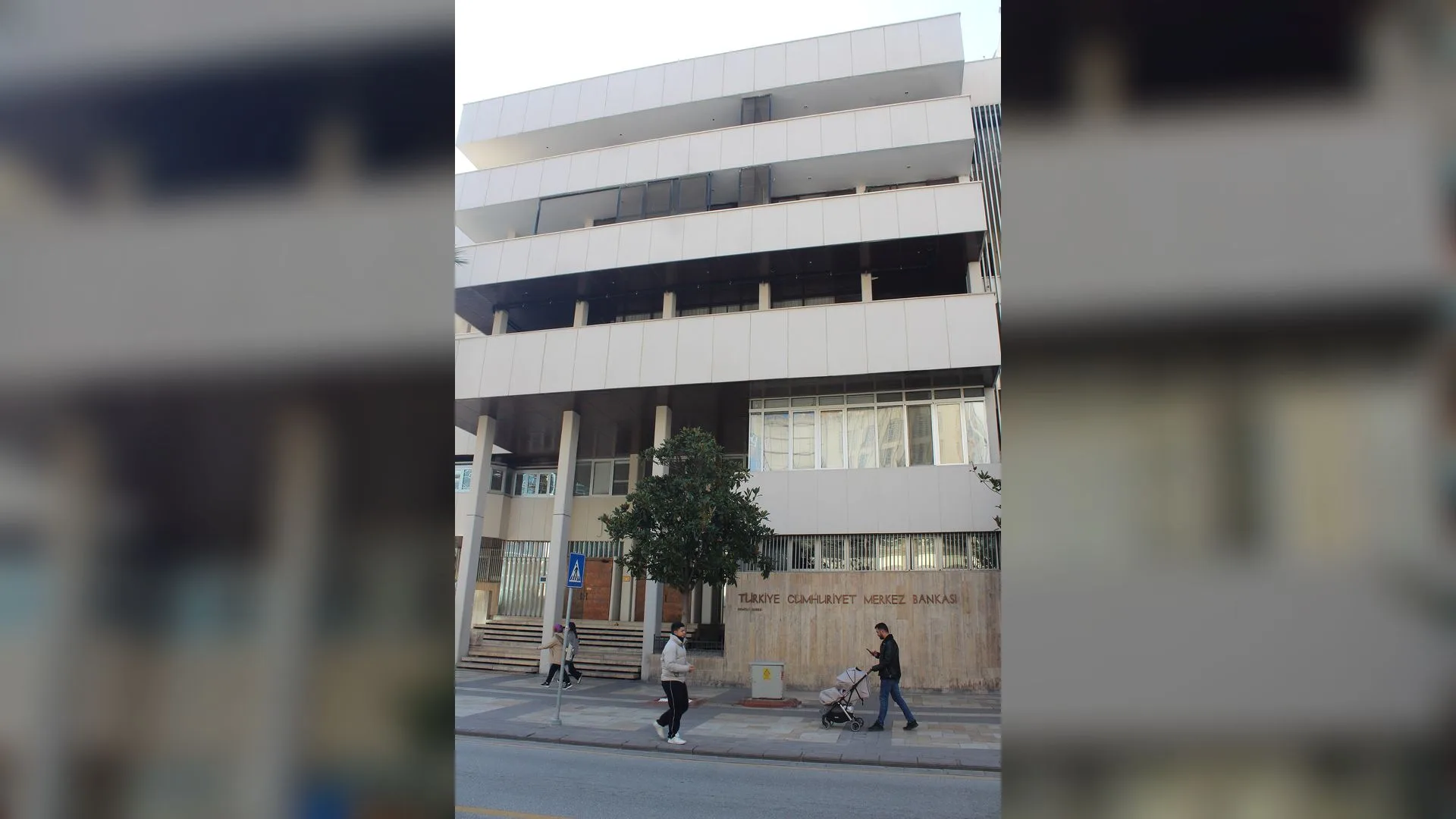 Önünden yayaların geçtiği, tabelasında Türkiye Cumhuriyet Merkez Bankası yazan beyaz bina