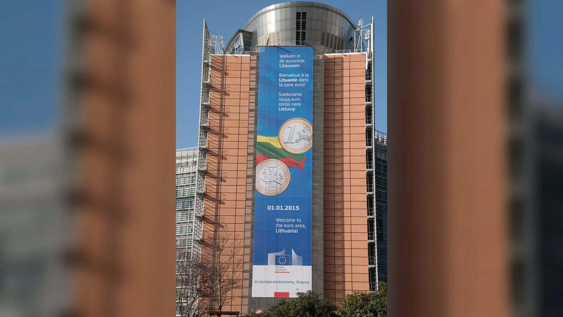 Cephesinde Litvanya bayrağı ve euro madeni paraları olan dev pankart asılı, yüksek bir ofis binası
