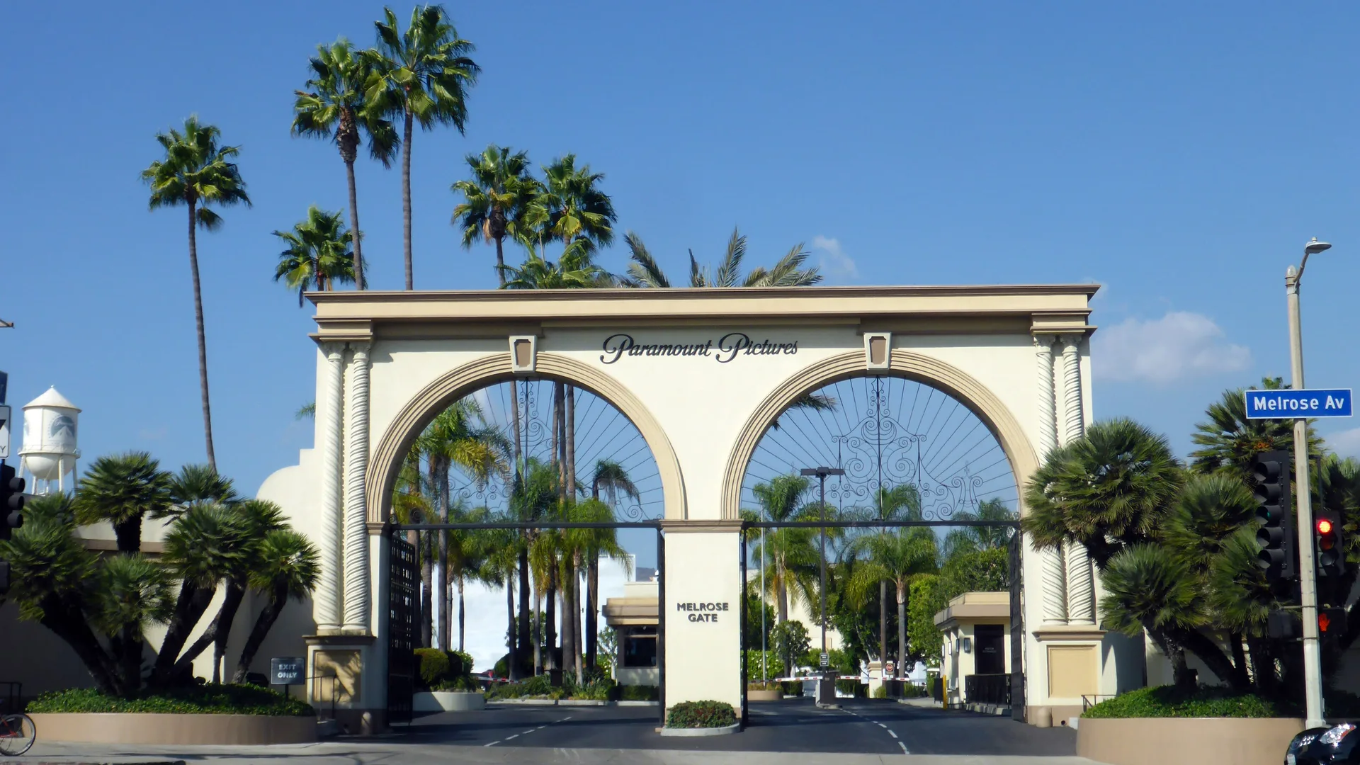 Palmiyelerle çevrili, üzerinde Paramount Pictures yazan kemerli Melrose Gate giriş kapısı