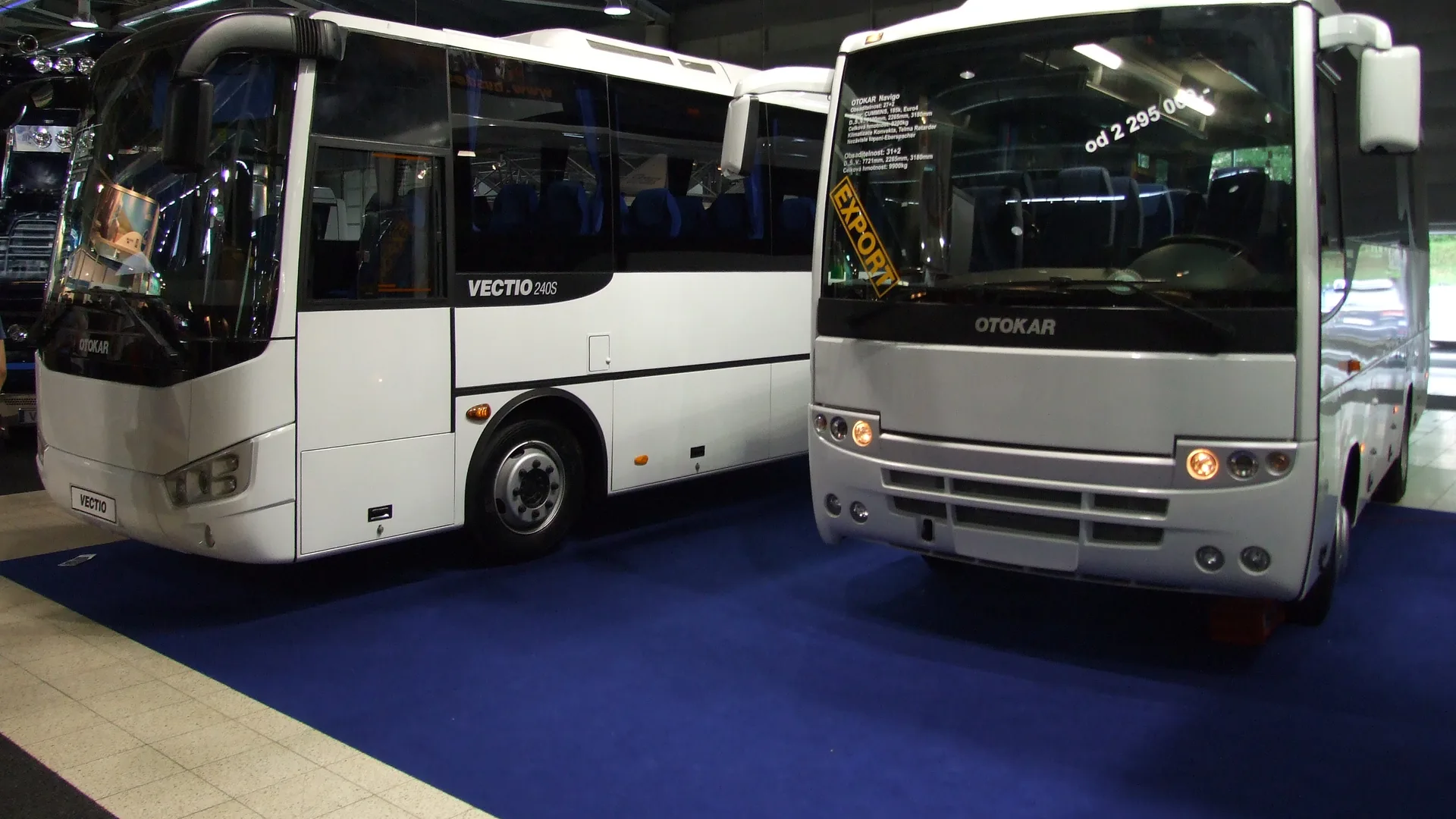 Fuar salonunda yan yana duran iki beyaz Otokar midibüs
