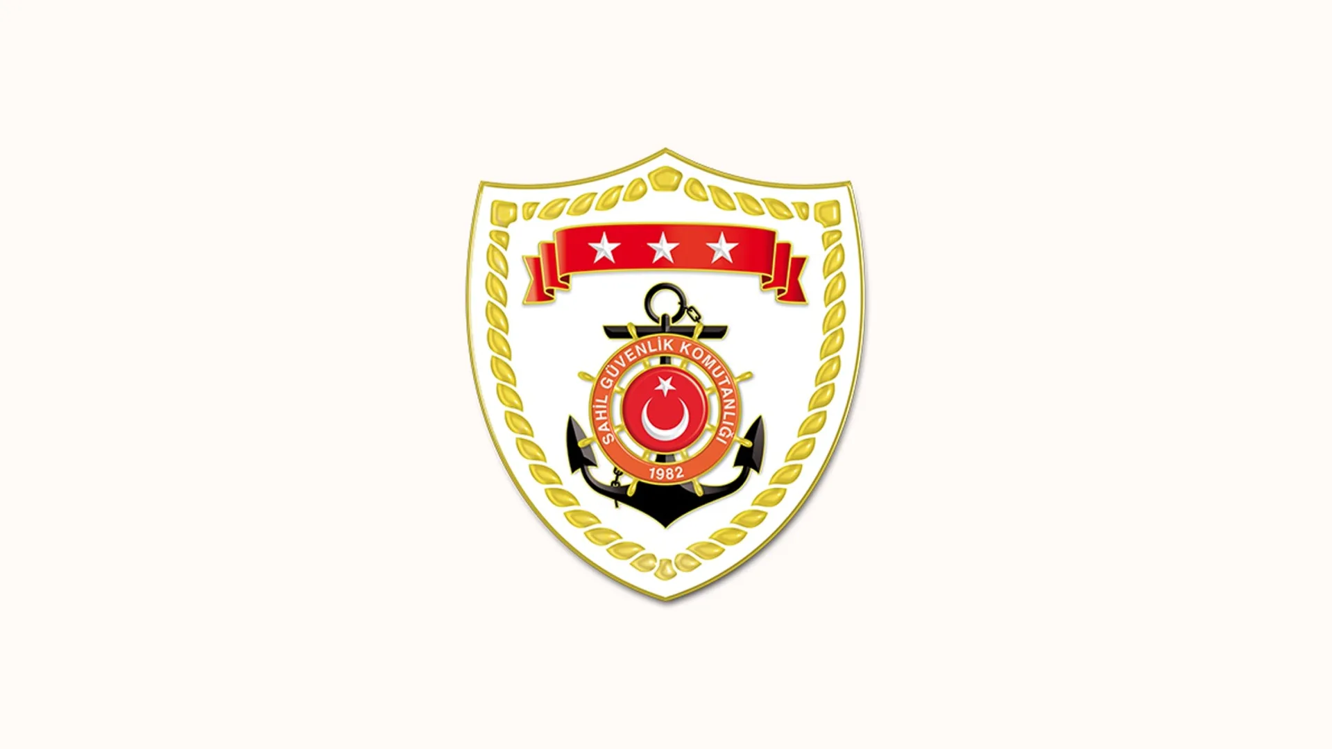 Çapa, dümen ve üç yıldızlı kırmızı şeritli Sahil Güvenlik Komutanlığı arması