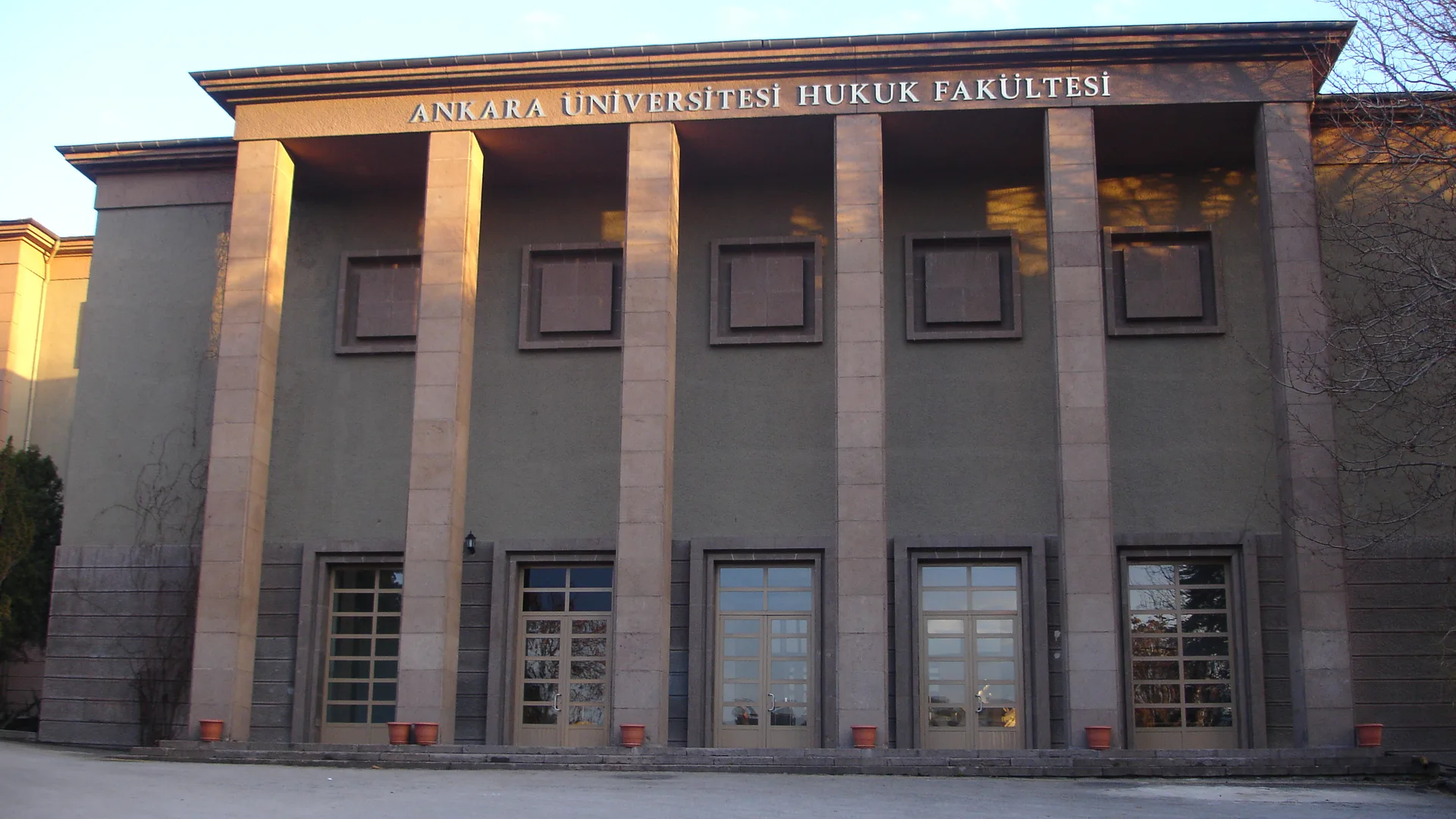 Sütunlu cephesinde Ankara Üniversitesi Hukuk Fakültesi yazan bina, gün batımı ışığında