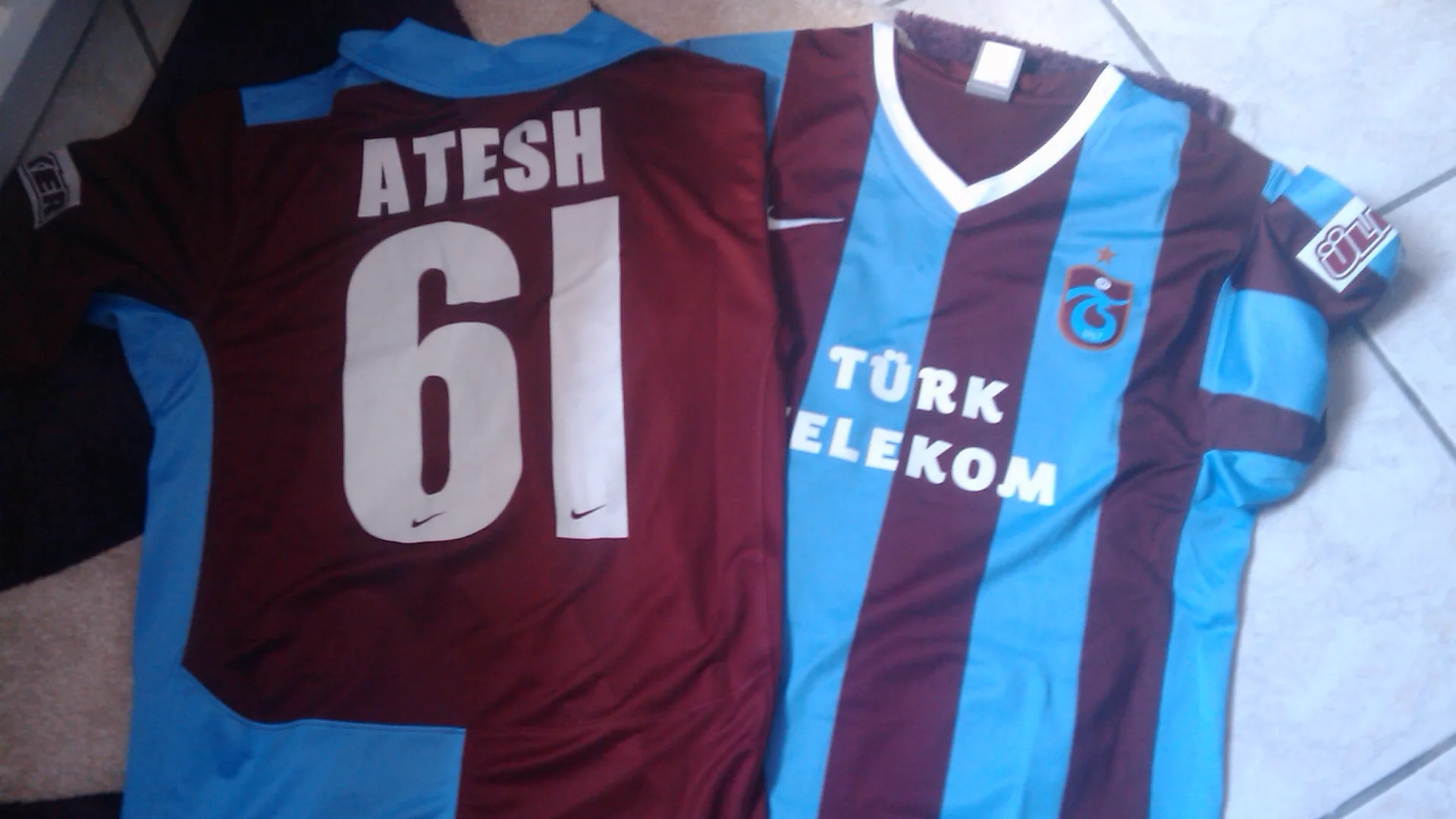 Bordo-mavi çizgili iki Trabzonspor forması, birinin sırtında ATESH 61 yazıyor