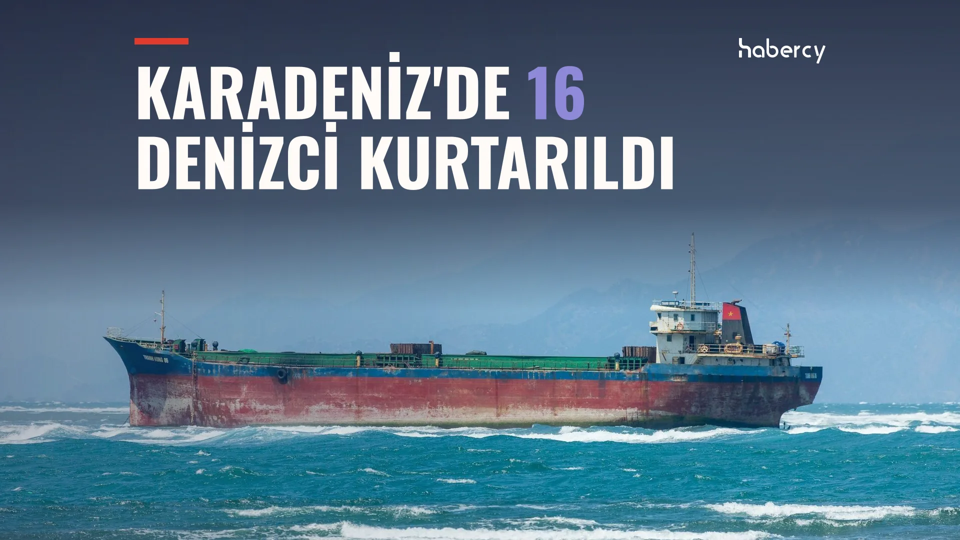 Dalgalı mavi denizde ilerleyen, gövdesi kırmızı ve lacivert büyük bir yük gemisi
