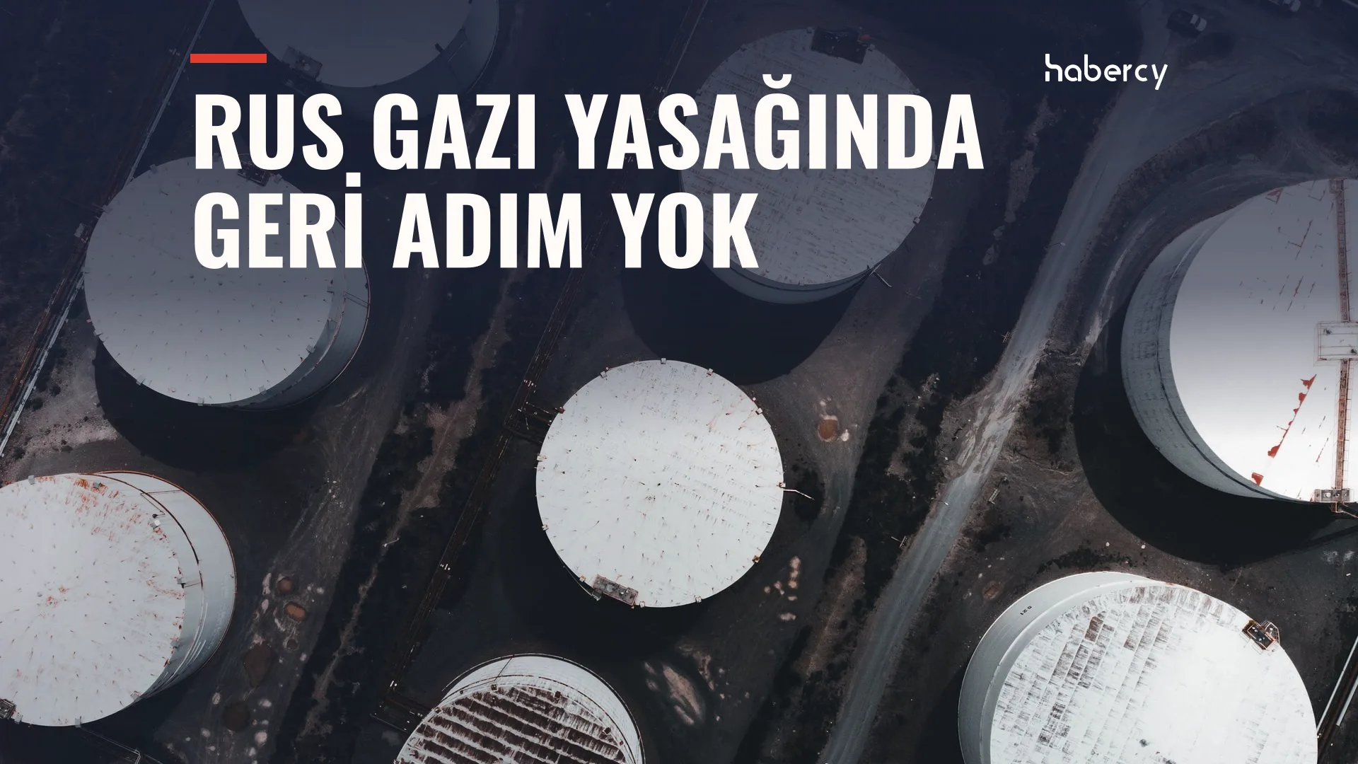 Yukarıdan çekilmiş, karanlık zeminde dizili beyaz yuvarlak depolama tankları