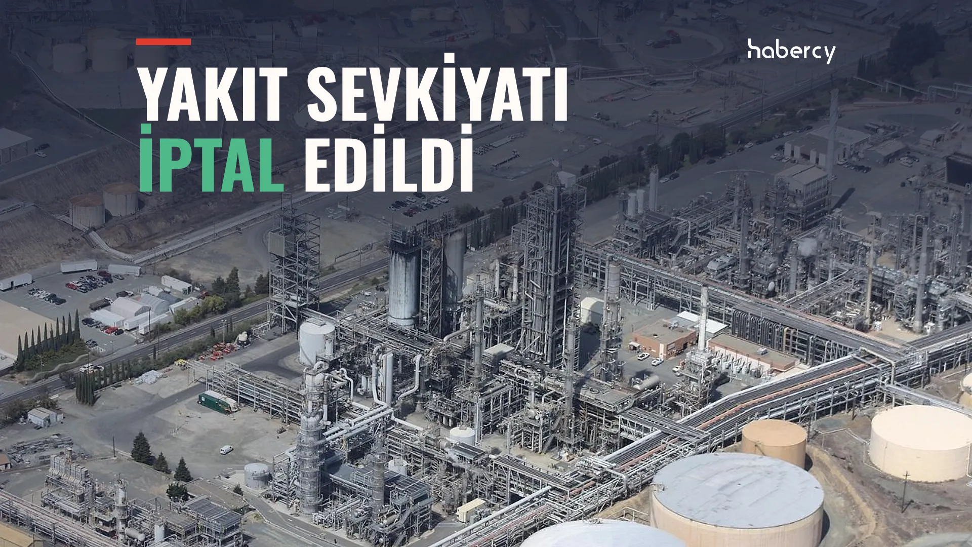 Havadan çekilmiş, boru hatları ve beyaz depolama tankları bulunan büyük bir rafineri tesisi