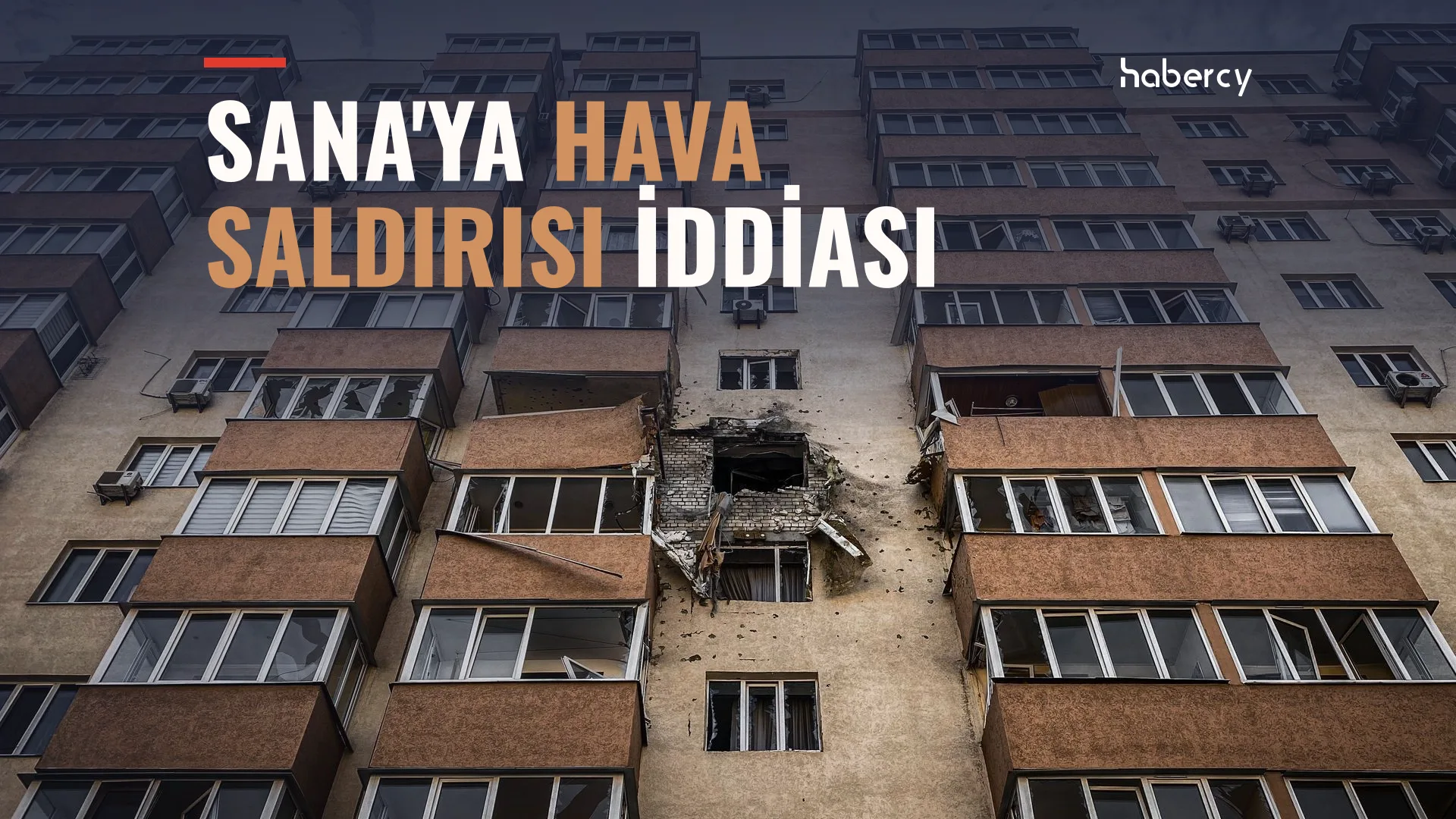 Cephesinde büyük bir delik ve hasar bulunan çok katlı bir apartman binası